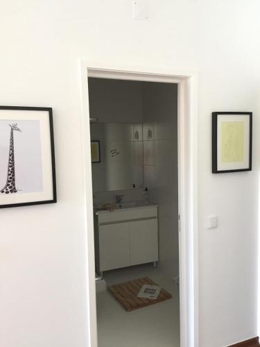 a white bathroom with a sink and a mirror at Tossan House in Vilamoura Downtown in Quarteira
