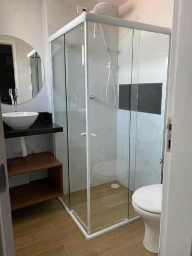 y baño con ducha de cristal y aseo. en Apartamento Studio Maceió, en Maceió