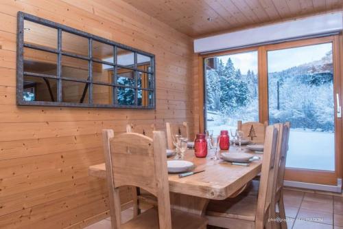 une salle à manger avec une table et des chaises en bois dans l'établissement Chalet Charligustine - Gérardmer - 8p (4 étoiles), à Gérardmer