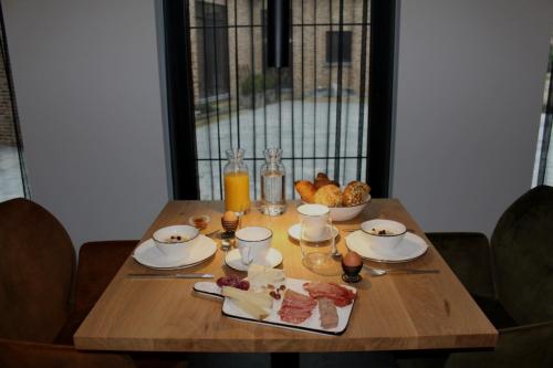 una mesa de madera con desayuno en B&B Punto Vélo, en Zutendaal