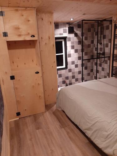 De Boshut Vledder في Vledder: غرفة نوم مع سرير وجدار بجدران مصدية