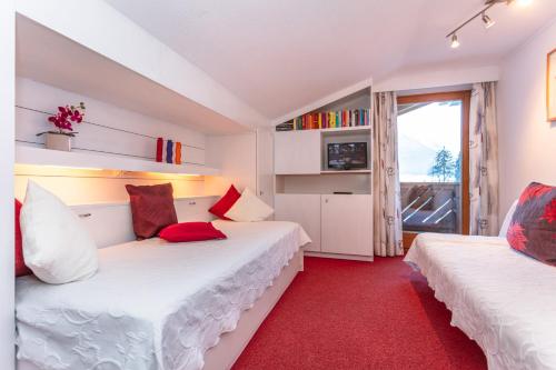 two beds in a room with a red carpet at Bergheim Komfort Ferienwohnungen in Walchsee