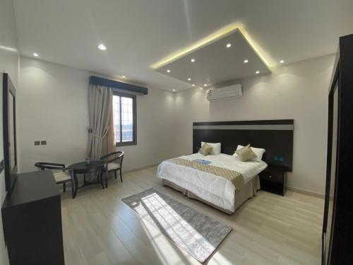 1 dormitorio con cama, escritorio y mesa en فلل ومسابح بلوسكاي, en Al Aqiq