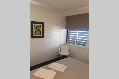 a room with a white chair and a window at Marina Mar in Vilamoura downtown in Quarteira