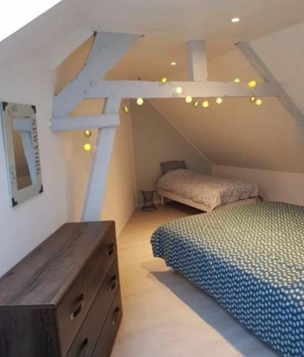 a attic room with two beds and a dresser at Longère entre terre et mer in Marquise