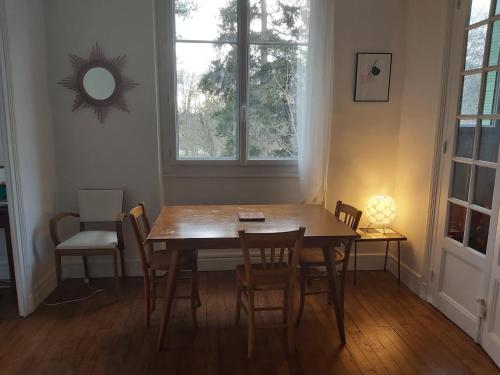 - une table à manger avec des chaises et un miroir mural dans l'établissement Sun palace, à Vichy