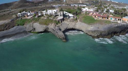 an aerial view of a rock bridge over the ocean at Hacienda Rancho Santini in Rosarito