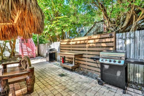 een achtertuin met een grill en een bank en een hek bij Sunrise Garden Resort in Anna Maria
