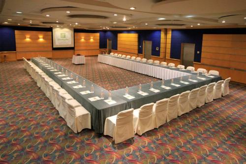 a row of tables and chairs in a banquet hall at Holiday Inn Monterrey-Parque Fundidora by IHG in Monterrey