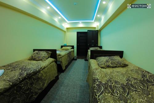 Habitación con 3 camas y luz azul en Hostel Buston, en Chkalovsk