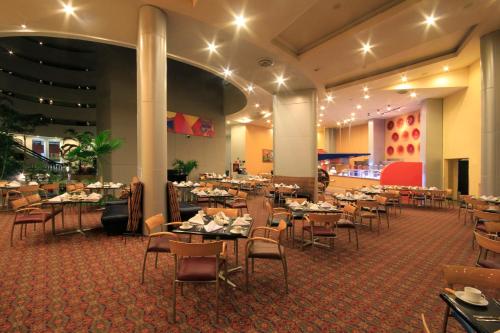 a dining room filled with tables and chairs at Holiday Inn Monterrey-Parque Fundidora by IHG in Monterrey
