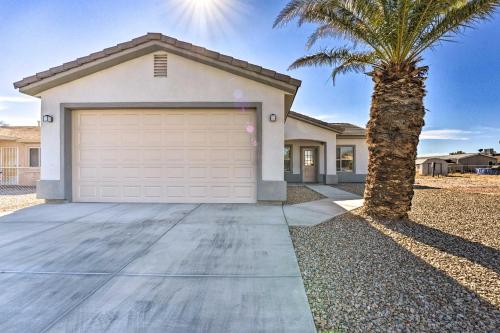 a palm tree in front of a house with a garage at Pet-Friendly Retreat - 1 Block to Colorado River! in Bullhead City