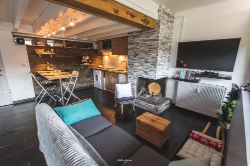 uma sala de estar com um sofá e uma cozinha em Gîte Le Petit Arbizon em Campan