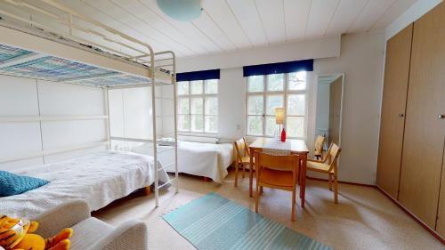 Villa Högbo في Iniö: غرفة نوم بسرير وطاولة وكراسي