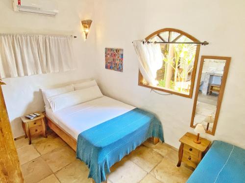 a small bedroom with a bed and a mirror at Villa Medina Jeri in Jericoacoara