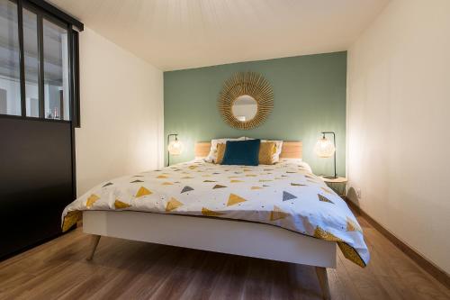 a bedroom with a bed and a mirror on the wall at Appart 4 pers design et cosy avec Jardin au Cœur de Sélestat in Sélestat