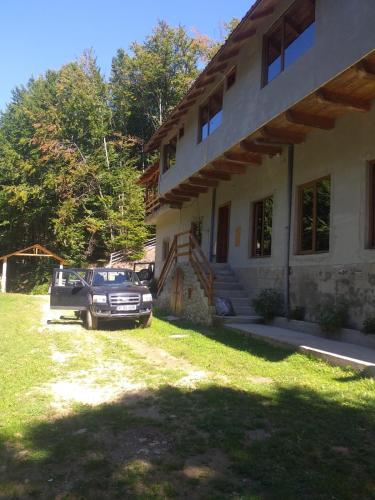 a truck parked in front of a house at Cabana Valea Bradului in Nucşoara