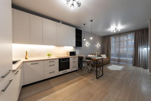 New modern apartments. metro Minskaya في كييف: مطبخ مع دواليب بيضاء وغرفة طعام
