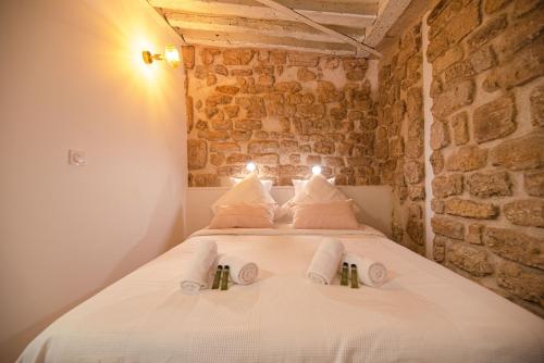 a bedroom with a white bed in a brick wall at Cosy home in Paris Center - With AC in Paris