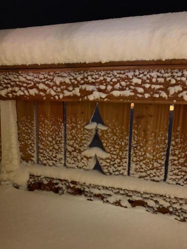 a building with snow on the side of it at Hôtel Les Mouflons in Le Mont-Dore