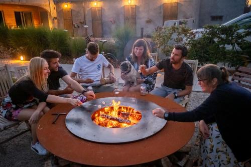 un gruppo di persone seduti intorno a un tavolo con una pizza di Vakantieverblijf Alfzotmolen a Beernem