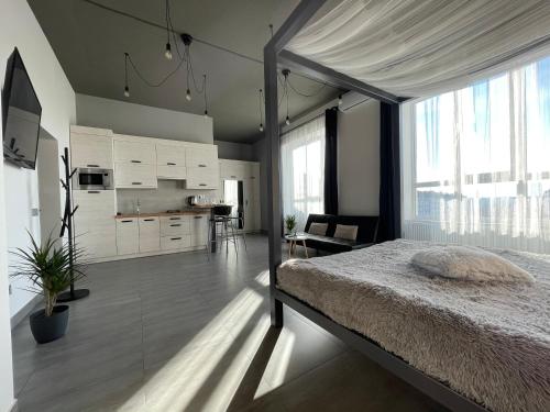 a bedroom with a large bed and a kitchen at Kalinova Sloboda Apartment in Ivano-Frankivsʼk
