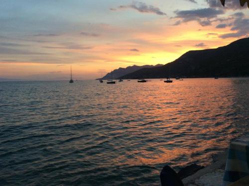 a sunset over a large body of water with boats at Harmony Seaside Pelion in Platanias