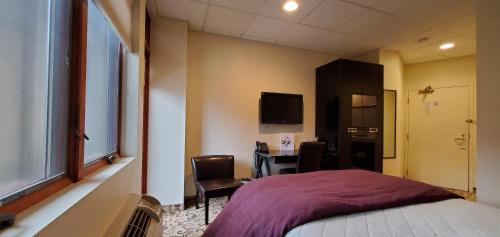 a bedroom with a bed and a desk and a tv at Lowell Inn in Stillwater