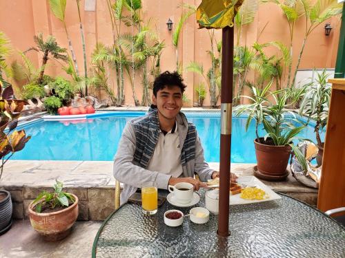 a man sitting at a table with a plate of food at Llaqta Wasi in Lima