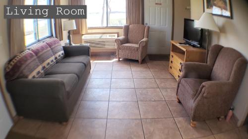 a living room with a couch and two chairs and a television at Lewis & Clark Resort in Yankton