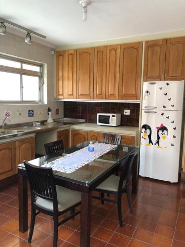 a kitchen with a table and a white refrigerator at Zen Garden Hostel Mirandópolis in Sao Paulo