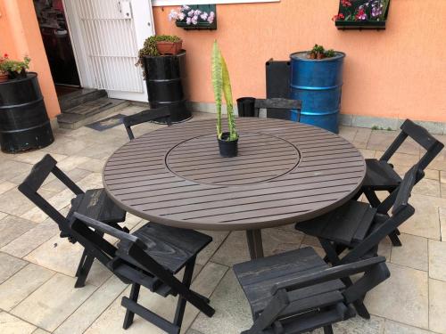 a wooden table with chairs and a potted plant on it at Zen Garden Hostel Mirandópolis in Sao Paulo