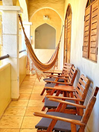 a group of chairs sitting in a room with a hammock at Villa Medina Jeri in Jericoacoara