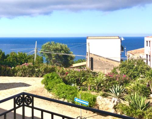 a view of the ocean from a balcony at Hotel Baglio Di Scopello in Scopello