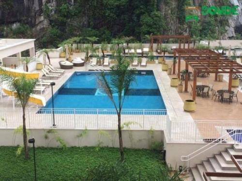 a large swimming pool with chairs and a table at Apto em santos 900 m praia in Santos