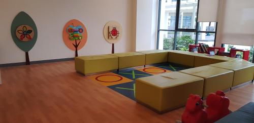 a waiting room with yellow furniture and mirrors at Mactan Newtown - New Modern Condo with Ocean View in Mactan
