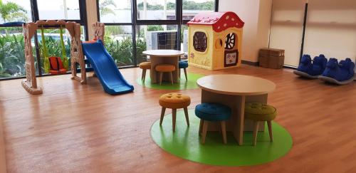a play room with a table and a playground at Mactan Newtown - New Modern Condo with Ocean View in Mactan