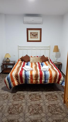 a bed in a bedroom with two tables and two lamps at Casitas Gutiérrez in Moya