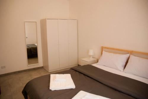 - une petite chambre avec un lit et un miroir dans l'établissement PicoBy Gazzi, à Messina