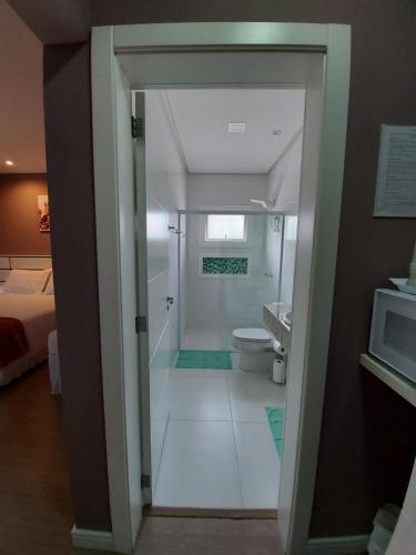a bathroom with a shower and a toilet in a room at Hospedagem Jardins de Gramado in Gramado
