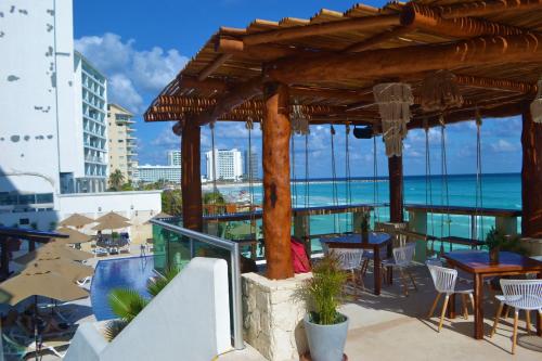 a patio with tables and chairs and a view of the ocean at Ocean View Condo in Cancún