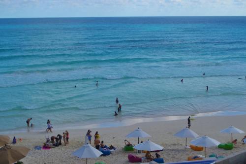 a group of people on a beach with the ocean at Ocean View Condo in Cancún