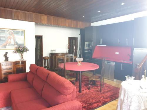 ein Wohnzimmer mit einem roten Sofa und einem Tisch in der Unterkunft Charming House Apendurada in Alpendurada