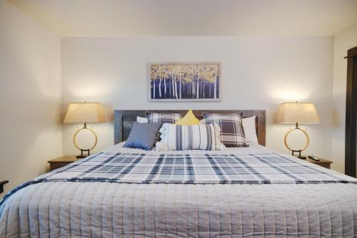 a bedroom with a blue and white bed with two lamps at Copper King Extended Stay Collection in Butte