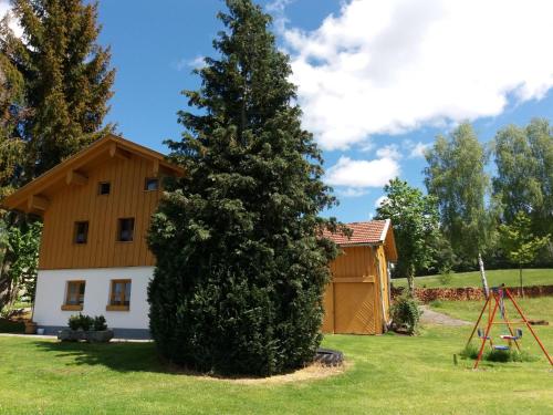 a large tree in front of a house at Lovely Holiday Home in Viechtach near the Forest in Viechtach