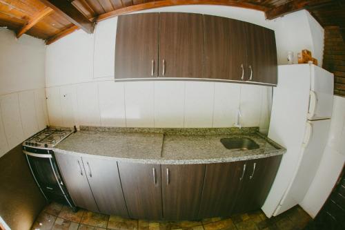 a small kitchen with a sink and a refrigerator at Hotel Tierra Colorada in Puerto Iguazú