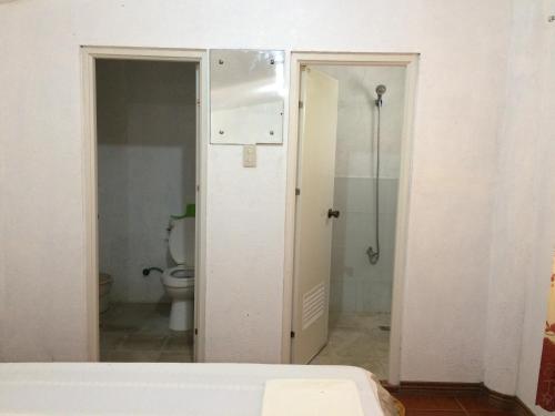 a bathroom with a toilet and a shower in a room at The Pelicans Resort in Batangas City