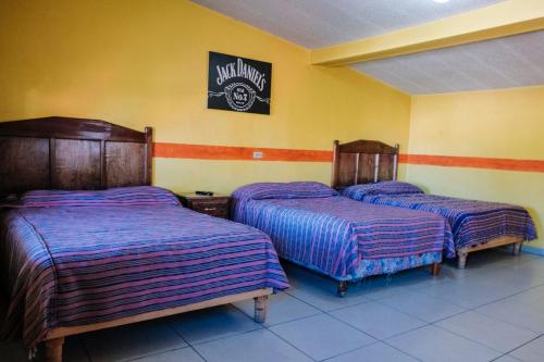 two beds in a room with yellow walls at Cabañas Margarito in Areponapuchi