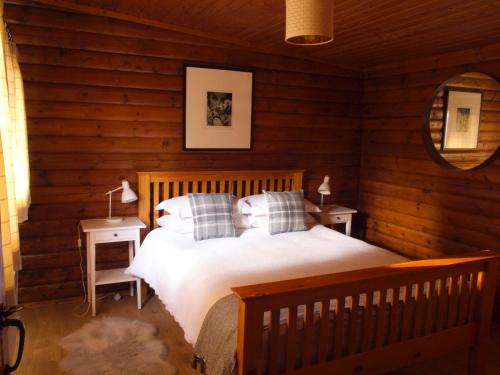 1 dormitorio con 1 cama en una cabaña de madera en Hillside Log cabin, Ardoch Lodge, Strathyre, en Strathyre