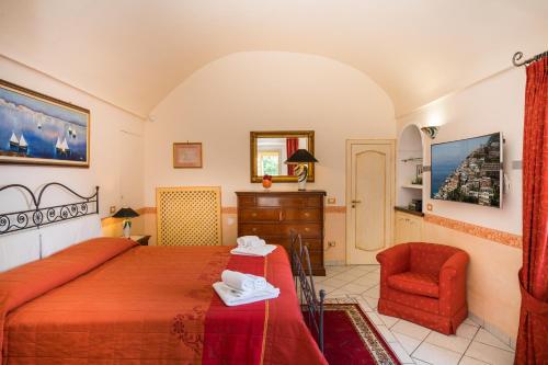 a bedroom with a red bed and a chair at De Vivo Realty - Ilary House Positano in Positano